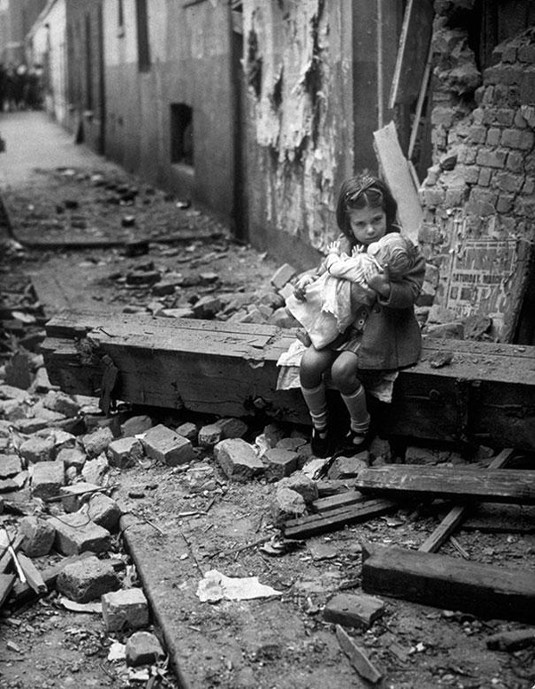 17.) This little girl sits with her doll in the ruins of her London home that was bombed in 1940.